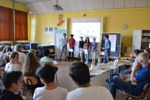 Eine Gruppe Jugendlicher präsentiert vor Publikum ihre Idee.