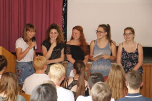 Eine Gruppe Mädchen steht vor Publikum und präsentiert ihr Projekt.